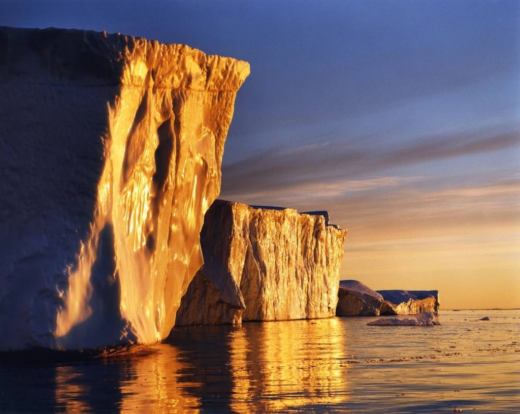 El hielo de la bahía de Disko, en Groenlandia, brilla en el punto donde atrapa el sol bajo del Ártico. El hielo de Groenlandia ha sido objeto de muchos estudios en los últimos años; con su actual ritmo de deshielo, los científicos predicen que perderá más hielo este siglo que en los últimos 12.000 años. Si la capa de hielo -una de las dos únicas del planeta junto con la de la Antártida- se derritiera por completo, el nivel global del mar aumentaría en 7,3 metros.